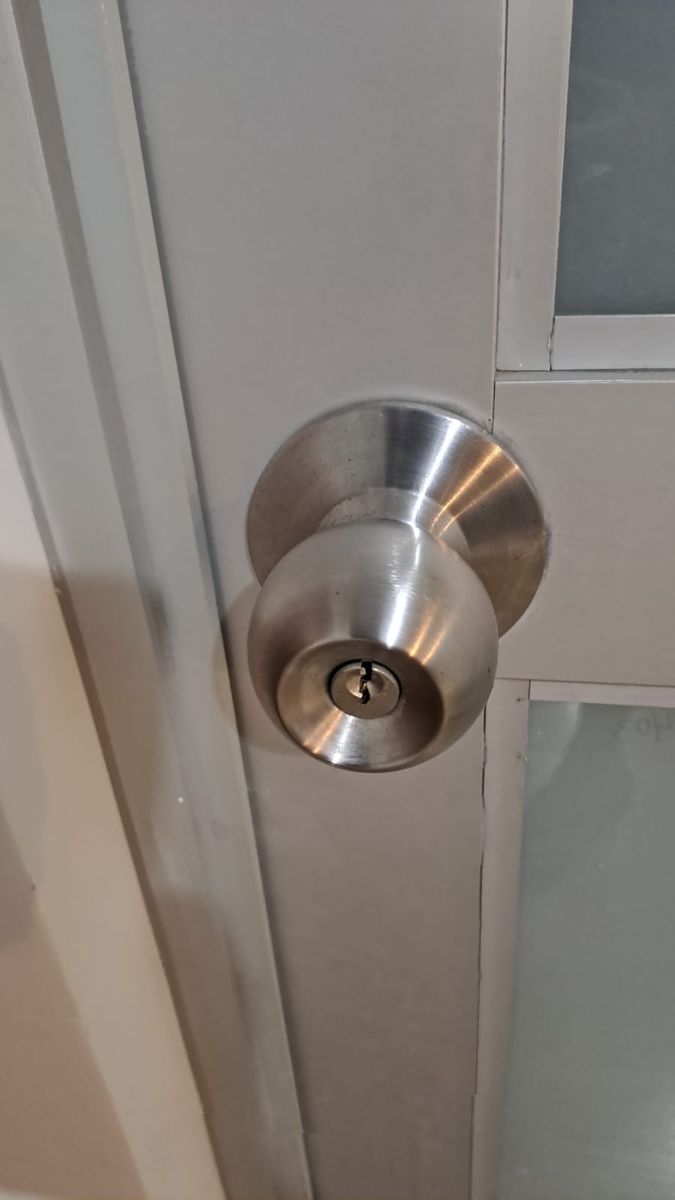 Pomo con llave en puerta de aluminio