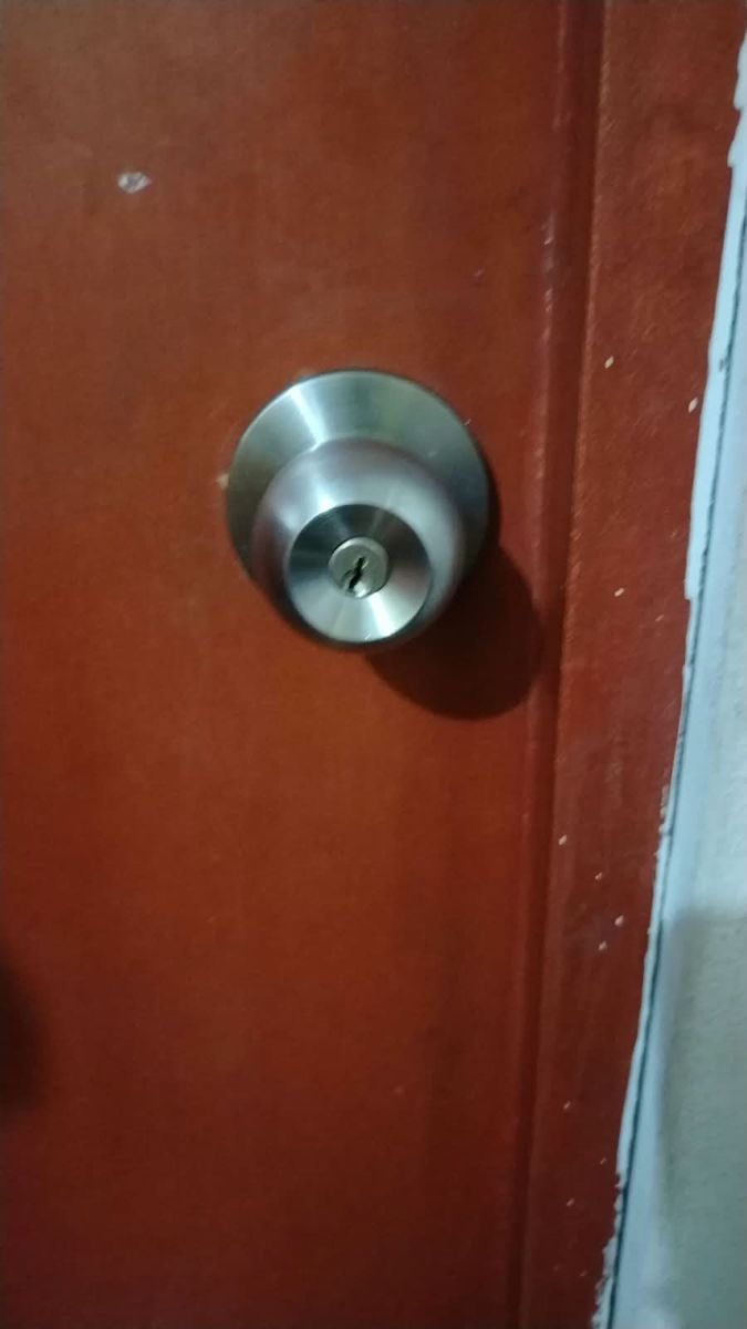 Pomo de acero con llave en puerta de habitación