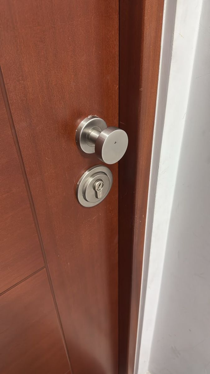 Puerta principal de madera con perilla y cilindro de seguridad